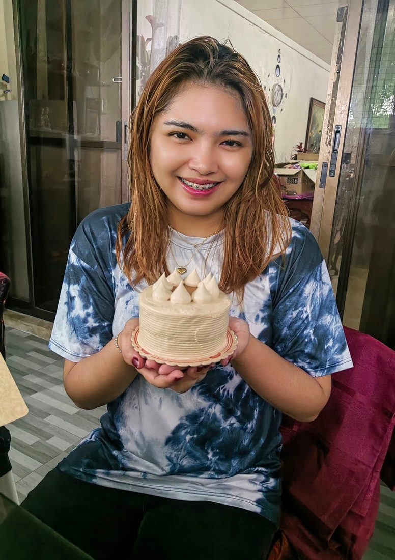 OM smiling, holding a birthday cake